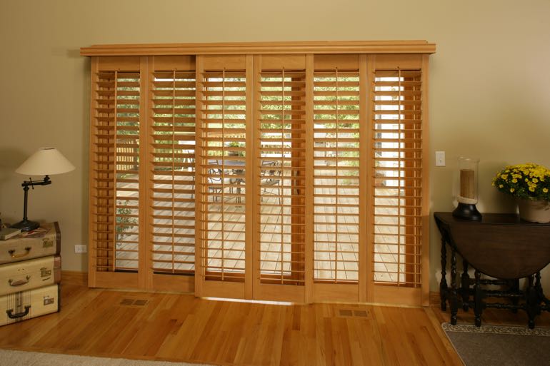 plantation shutters on sliding door connecting to outdoor porch.